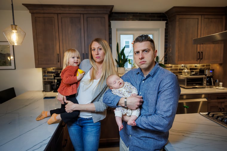 Trevor Otto, a former employee of the General Services Administration in Philadelphia, lost his job during recent downsizing of the federal government. With him are (from left) his daughter Devon, 2½; wife Jenna; and 7-week-old daughter Vivienne in their West Chester home.