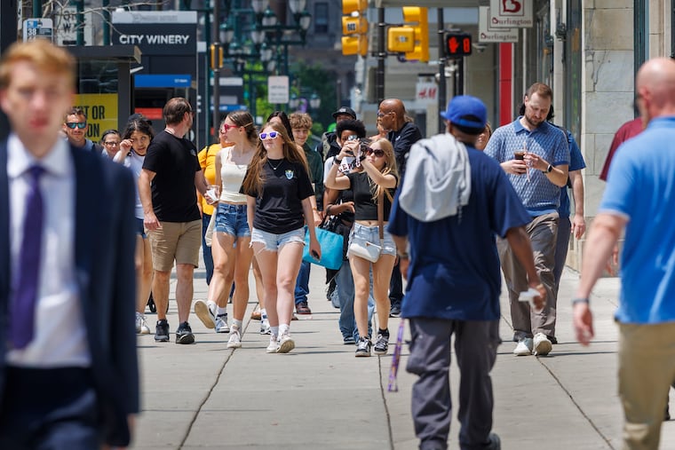 Pedestrians ambling in Center City on Tuesday as temperatures climb and veils of smoke fill the air. It's going to get steamier Wednesday.