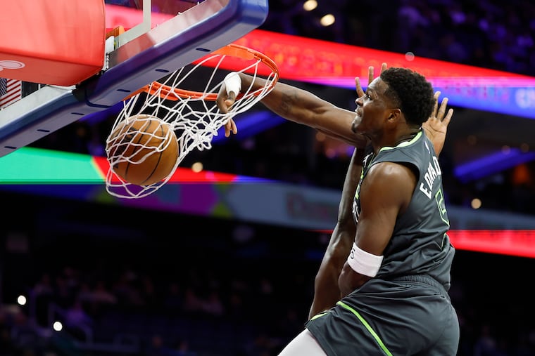 Timberwolves guard Anthony Edwards dunks the basketball past Sixers center Adem Bona in the first quarter.