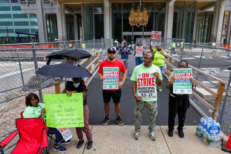 Members of Philadelphia municipal workers, AFSCME District Council 33 hold signs as they stand outside the Municipal Services Building across from City Hall, on Tuesday, July 1, 2025. (Alejandro A Alvarez/The Philadelphia Inquirer via AP)