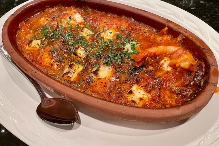 Shrimp saganaki is a sharing appetizer that showcases shrimp baked with feta in a subtly spiced tomato and leek sauce.