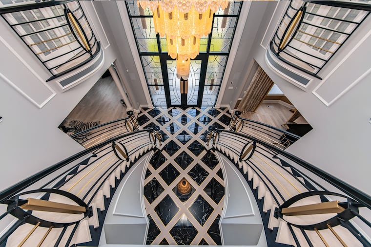 Homeowner and interior designer Romina Ustayev had a Spanish glass chandelier custom made to fit the foyer of her Northampton Township home, now on the market for $3.5 million. The home's entrance also has a grand double staircase.