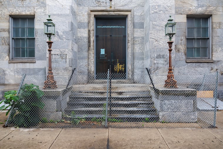 Chainlink fencing sags around the front steps of the boarded-up, marble facade of the Atwater Kent building, as seen on June 10.