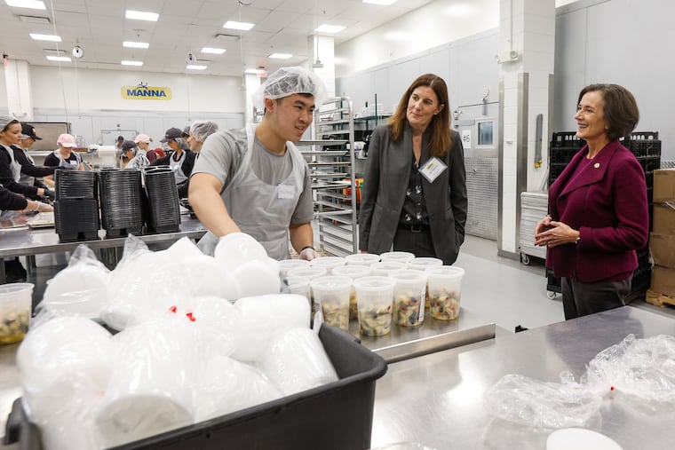 Andrew Louie prepares meals with MANNA CEO Sue Daugherty (center) and then-DHS Secretary Val Arkoosh as she visits MANNA to discuss the nonprofit's medically tailored meals for chronically ill patients on Medicaid in November 2023.