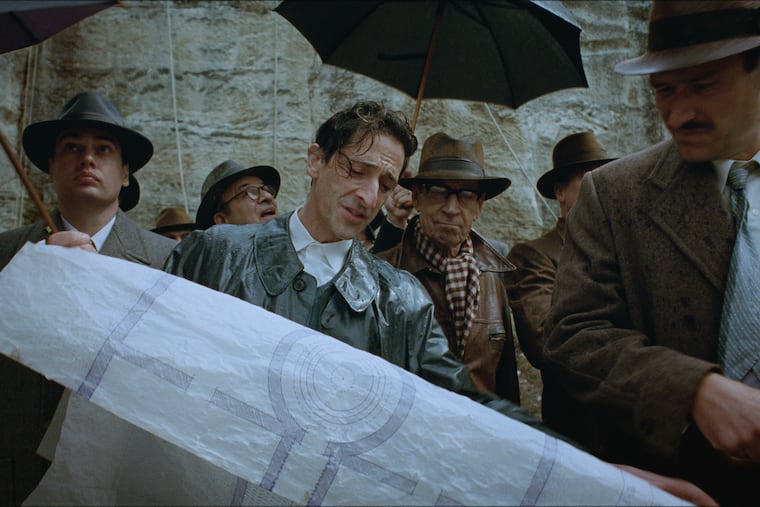 This image released by A24 shows Adrien Brody, center, in a scene from "The Brutalist." (Lol Crawley/A24 via AP)