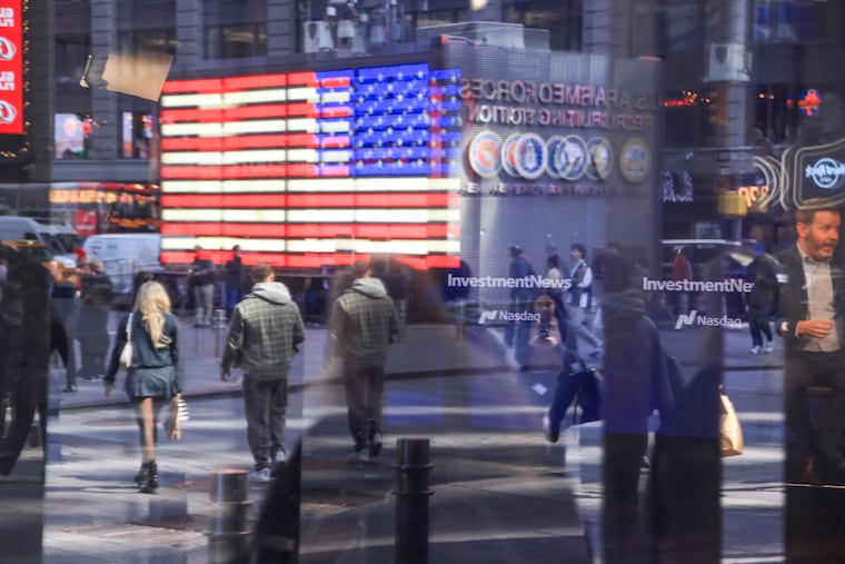 Times Square is reflected in the windows of the Nasdaq MarketSite in New York on March 11.