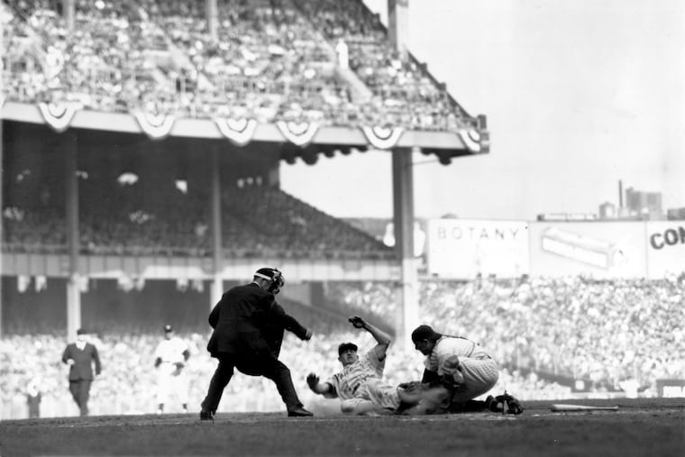 New York Yankees catcher Yogi Berra tags the sliding Philadelphia Phillies shortstop Granny Hamner for an out at home plate in the 4th inning in the fourth and final World Series game at Yankee Stadium in New York City in 1950.