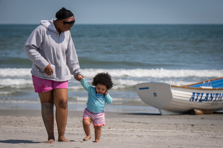 Jianna Cassell, left, walks on the beach with her little sister Mariyah Spence in Atlantic City last month.