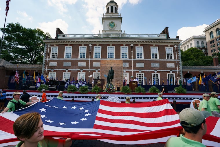 An oversized replica of the flag sewn by Betsy Ross is carried past Independence Hall during the 2019 Salute to America Independence Day Parade.