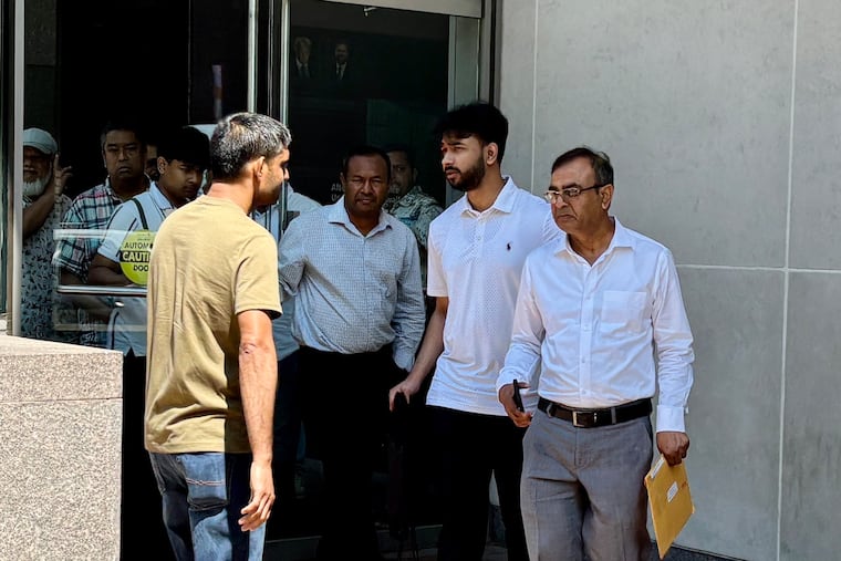 Md Munsur Ali (far right, holding envelope) exits the federal courthouse in Center City on Thursday after being sentenced to 21 months in prison.