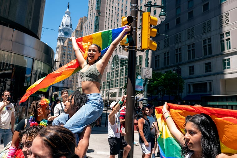 Kimberly Orozco rides on the shoulders of Keven Collins as they march up Market Street as the city's 50th annual Pride celebration kicks off on June 5, 2022, with the Pride March, hosted in collaboration with the Philly Dyke March.